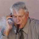 Former Golden State Warriors head coach Don Nelson smokes a cigar while talking on the phone outside of the Warriors NBA training facility in Oakland, Calif., Tuesday, Aug. 28, 2012. Nelson always did things his way, and it hardly mattered who objected to his coaching techniques. He is the NBA's winningest coach ever because of it, and, now, a Hall of Famer. And, don't forget, he's the one who could regularly be seen smoking a cigar in the parking lot before games. (AP Photo/Jeff Chiu)