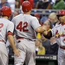 St. Louis Cardinals' Carlos Beltran, right, greets Matt Holliday, center, and Matt Carpenter, after they scored on a double by Cardinals' Allen Craig Pittsburgh Pirates starting pitcher James McDonald during the second inning of a baseball game in Pittsburgh Monday, April 15, 2013. Players on both teams wore No. 42 in honor of Jackie Robinson. (AP Photo/Gene J. Puskar)