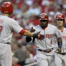 Cincinnati Reds' Brandon Phillips, center, and Shin-Soo Choo, left, celebrate as Ryan Ludwick, right, watches after scoring on a two-run single by Jay Bruce during the first inning of a baseball game against the St. Louis Cardinals, Wednesday, Aug. 28, 2013, in St. Louis. (AP Photo/Jeff Roberson)