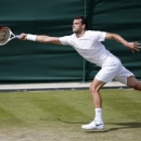 Grigor Dimitrov of Bulgaria stretches to return to Grega Zemlja of Slovenia during their Men's second round singles match at the All England Lawn Tennis Championships in Wimbledon, London, Thursday, June 27, 2013. (AP Photo/Sang Tan)