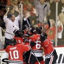 Chicago Blackhawks' Brent Seabrook, pinned to the wall, celebrates with his teammates after scoring in overtime in Game 7 of the NHL hockey Stanley Cup Western Conference semifinals against the Detroit Red Wings, Wednesday, May 29, 2013, in Chicago. The Blackhawks won 2-1. (AP Photo/Nam Y. Huh)