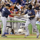 Atlanta Braves' Justin Upton, right, is congratulated by third base coach Brian Snitker after Upton hit a home run during the sixth inning of a baseball game against the Miami Marlins, Monday, April 8, 2013, in Miami. (AP Photo/J Pat Carter)