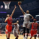 San Antonio Spurs guard Danny Green (4) drives to the basket past Chicago Bulls center Joakim Noah (13) and guard Richard Hamilton (32) as Spurs' Boris Diaw watches during the first half of an NBA basketball game, Monday, Feb. 11, 2013, in Chicago. (AP Photo/Charles Rex Arbogast)