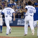 Toronto Blue Jays' Rajai Davis, left, turns to celebrate with on rushing teammates after hitting a game-winning single during the ninth inning against Baltimore Orioles baseball game in Toronto on Friday June 21, 2013. (AP Photo/The Canadian Press, Chris Young)