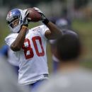 New York Giants wide receiver Victor Cruz (80) catches a pass from Giants quarterback Eli Manning during a practice at the New York Giants football training camp in Albany, N.Y., Friday, July 27, 2012. (AP Photo/Kathy Willens)