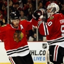 Chicago Blackhawks' Duncan Keith, left, is congratulated by Blackhawks goalie Corey Crawford in the first period after Keith scored against the Detroit Red Wings during an NHL hockey game in Chicago, Sunday, Jan. 27, 2013. (AP Photo/John Smierciak)