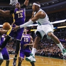 Boston Celtics forward Paul Pierce (34) dumps off the ball to center Jason Collins (98) as he is pressured by Los Angeles Lakers center Dwight Howard (12) during the first quarter of an NBA basketball game in Boston, Thursday, Feb. 7, 2013. At right is Lakers guard Kobe Bryant (24). (AP Photo/Charles Krupa)