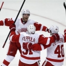 Detroit Red Wings center Valtteri Filppula, center celebrates his goal with right wing Daniel Cleary, left, and center Henrik Zetterberg during the second period in Game 7 of their first-round NHL hockey Stanley Cup playoff series against the Anaheim Ducks in Anaheim, Calif., Sunday, May 12, 2013. (AP Photo/Chris Carlson)
