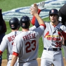 St. Louis Cardinals' Pete Kozma, right, high-fives teammates David Freese and Daniel Descalso after batting them with on a three-run home run in the second inning of Game 3 of the National League division baseball series against the Washington Nationals on Wednesday, Oct. 10, 2012, in Washington. (AP Photo/Nick Wass)