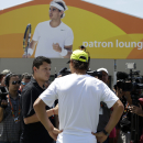 Rafael Nadal, of Spain, center, is interviewed by the news media as an image of him is displayed on a tent at the Miami Open tennis tournament, Tuesday, March 24, 2015, in Key Biscayne, Fla. Nadal plays his first match Friday. (AP Photo/Lynne Sladky)