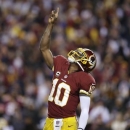 Washington Redskins quarterback Robert Griffin III celebrates a touchdown during the first half of an NFL football game against the Dallas Cowboys on Sunday, Dec. 30, 2012, in Landover, Md. (AP Photo/Evan Vucci)
