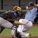 Tampa Bay Rays' Carlos Pena, right, slides safely into home plate ahead of the throw to Miami Marlins catcher John Buck, left, during the fifth inning of an interleague baseball game on Friday, June 15, 2012, in St. Petersburg, Fla. Pena scored on a single by teammate Will Rhymes. (AP Photo/Chris O'Meara)
