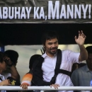 Boxer Manny Pacquiao waves to the crowds during a motorcade in Manila May 13, 2015, after arrving from Las Vegas.    REUTERS/Romeo Ranoco