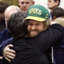 Jason Reid, right, a longtime Seattle SuperSonics fan, hugs another supporter after a hearing in King County Superior Court on Friday, Feb. 22, 2013, in Seattle. A state judge rejected a lawsuit aimed at undoing a deal to build a new professional basketball and hockey arena in Seattle, a key part of plans to bring the NBA back to town. King County Superior Court Judge Douglass North held that the agreement between the city of Seattle, King County and an investment group led by hedge fund manager Chris Hansen does not violate state environmental law. The International Longshore and Warehouse Union is concerned that adding a third stadium to the area south of downtown would choke freight traffic and cost jobs. The union sued, saying an environmental review should have preceded any agreement. (AP Photo/Elaine Thompson)