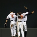 Baltimore Orioles outfielders, from left, Nate McLouth, Nick Markakis and Adam Jones celebrate after the Orioles defeated the Washington Nationals 9-6 in a baseball game Wednesday, May 29, 2013, in Baltimore. (AP Photo/Patrick Semansky)