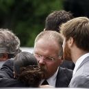 Philladephia Eagles coach Andy Reid, center, is embraced after the funeral for his son Garrett Reid, Tuesday, Aug. 7, 2012 in Broomall, Pa. Reid, 29, was found dead Sunday morning, Aug. 5, in a dorm room at the team's Lehigh University NFL football training camp. Looking on at right are his wife Tammy and son Britt. (AP Photo/Brynn Anderson)