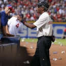 A security official shouts to fans to not throw trash on the field during the eighth inning of the National League wild card playoff baseball game between the Atlanta Braves and the St. Louis Cardinals, Friday, Oct. 5, 2012, in Atlanta. The Cardinals won baseball's first wild-card playoff, taking advantage of a disputed infield fly call that led to a protest and fans littering the field with debris to defeat the Braves 6-3. (AP Photo/Todd Kirkland)