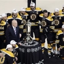 The Boston Bruins pose with the trophy after beating the Pittsburgh Penguins 1-0 in Game 4 of the Eastern Conference finals of the NHL hockey Stanley Cup playoffs, in Boston on Friday, June 7, 2013. The Bruins advanced to the Stanley Cup finals. (AP Photo/Charles Krupa)