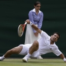 Ivan Dodig of Croatia slips after returning to David Ferrer of Spain in their Men's singles match at the All England Lawn Tennis Championships in Wimbledon, London, Monday, July 1, 2013. (AP Photo/Anja Niedringhaus)