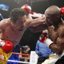 FILE - In this May 2, 2015 file photo, Manny Pacquiao, left, from the Philippines, trades blows with Floyd Mayweather Jr., during their welterweight title fight in Las Vegas. Pacquiao lost his biggest fight in the ring, but that won't stop him from plotting a bigger comeback - in the political arena that is. Some fans still want a rematch because they felt cheated by the lackluster Pacquiao-Mayweather bout billed by promoters as the 