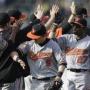 Baltimore Orioles, including Nate McLouth (9) and Endy Chavez (27), celebrate at the end of a baseball game against the Oakland Athletics, Sunday, Sept. 16, 2012, in Oakland, Calif. The Orioles won 9-5.(AP Photo/Ben Margot)