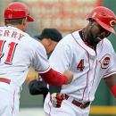 Cincinnati Reds' Brandon Phillips (4) is congratulated by third base coach Mark Berry (41) after hitting a two-run home run off Atlanta Braves starting pitcher Brandon Beachy in the first inning of a baseball game, Tuesday, May 22, 2012, in Cincinnati. (AP Photo/Al Behrman)