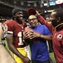 Washington Redskins quarterback Robert Griffin III (10) poses for a photo with filmmaker Spike Lee, center, after an NFL football game against the New Orleans Saints in New Orleans, Sunday, Sept. 9, 2012. The Redskins won 40-32. (AP Photo/Matthew Hinton)