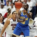 UCLA's Shabazz Muhammad (15) passes under pressure from Arizona's Nick Johnson (13) during the first half of an NCAA college basketball game at McKale Center in Tucson, Ariz., Thursday, Jan. 24, 2013. UCLA won 84-73. (AP Photo/John Miller)