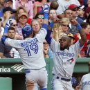 Toronto Blue Jays' Jose Bautista (19) celebrates his solo home run with teammate Jose Reyes, second from right, in the sixth inning of a baseball game against the Boston Red Sox in Boston, Saturday, June 29, 2013. (AP Photo/Michael Dwyer)