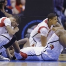 Louisville's Peyton Siva, left, Chane Behanan, center, and Wayne Blackshear (20) react to LKevin Ware's injury during the first half of the Midwest Regional final in the NCAA college basketball tournament, Sunday, March 31, 2013, in Indianapolis. (AP Photo/Michael Conroy)
