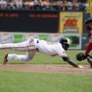 Baltimore Orioles' Xavier Avery, left, slides home to score a run against Boston Red Sox catcher Kelly Shoppach, right, on a sacrifice fly by Chris Davis during the first inning of a baseball game, Wednesday, May 23, 2012, in Baltimore. (AP Photo/Nick Wass)