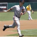 San Francisco Giants' Buster Posey rounds third base after hitting a two-run home against the Oakland Athletics' during the first inning of an interleague baseball game on Sunday, June 24, 2012, in Oakland, Calif. Athletics' Cliff Pennington, background, reacts. (AP Photo/George Nikitin)