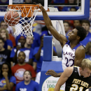 Kansas' Andrew Wiggins (22) gets past Fort Hays State's Jake Stoppel to dunk the ball during the second half of an exhibition NCAA college basketball game Tuesday, Nov. 5, 2013, in Lawrence, Kan. Kansas won the game 92-75. (AP Photo/Charlie Riedel)