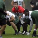 New York Jets quarterback Tim Tebow, center, prepares for the snap during team practice Thursday, May 24, 2012, in Florham Park, N.J. (AP Photo/Julio Cortez)
