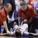 Trainers check on Louisville guard Kevin Ware (5) after an injury during the first half of the Midwest Regional final against Duke in the NCAA college basketball tournament, Sunday, March 31, 2013, in Indianapolis. (AP Photo/Michael Conroy)