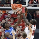 Louisville's Gorgui Dieng, right, dunks over Kentucky's Alex Poythrees, left, and Kyle Wiltjer during the first half of an NCAA college basketball game Saturday, Dec. 29, 2012, in Louisville, Ky. (AP Photo/Timothy D. Easley)