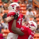 SMU offensive linesman Bryan Collins (67) picks up running back Zach Line (48) in celebration after Line scored a touchdown against Hawaii in the second quarter of the Hawaii Bowl, an NCAA college football game Monday, Dec. 24, 2012, in Honolulu. (AP Photo/Eugene Tanner)