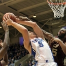 Duke's Mason Plumlee (5) is fouled on a drive by Santa Clara's Robert Garrett, right, and Raymond Cowels III, left, during the first half of an NCAA college basketball game in Durham, N.C., Saturday, Dec. 29, 2012.  (AP Photo/Ted Richardson)