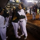 Oakland Athletics manager Bob Melvin hugs Coco Crisp, right, after the A's lost 6-0 to the Detroit Tigers in Game 5 of an American League division baseball series in Oakland, Calif., Thursday, Oct. 11, 2012. (AP Photo/Marcio Jose Sanchez)