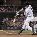Minnesota Twins' Joe Mauer hits an RBI single in the seventh inning of a baseball game, as the Twins came from behind to beat the New York Yankees 5-4 in a baseball game Tuesday, Sept. 25, 2012 in Minneapolis. At right is Yankees catcher Russell Martin who had a solo home run in the game. (AP Photo/Jim Mone)