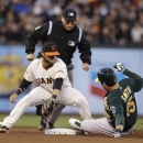 Oakland Athletics' Seth Smith slides safely into second base for a double in front of San Francisco Giants shortstop Brandon Crawford during the fourth inning of a baseball game Wednesday, May 29, 2013, in San Francisco. In the background is second base umpire Mark Carlson. (AP Photo/Eric Risberg)