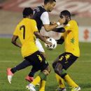 United States' Clint Dempsey, center, is challenged by Jamaica's Jason Morrison, left, and Jevaughn Watson during a 2014 World Cup qualifying soccer match in Kingston, Jamaica, Friday, Sept. 7, 2012. (AP Photo/Collin Reid)