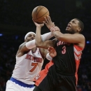 Toronto Raptors' Kyle Lowry (3) is fouled by New York Knicks' Carmelo Anthony (7) during the second half of an NBA basketball game Wednesday, Feb. 13, 2013, in New York. The Raptors won 92-88. (AP Photo/Frank Franklin II)