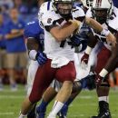 South Carolina's Connor Shaw, middle, escapes the grasp of Kentucky's T.J. Jones during the second quarter of an NCAA college football game in Lexington, Ky., Saturday, Sept. 29, 2012. (AP Photo/James Crisp)