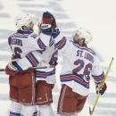 New York Rangers left wing Carl Hagelin (62), of Sweden, and right wing Martin St. Louis (26) congratulate center Derick Brassard (16) after his third goal, during the third period of Game 6 of the Eastern Conference finals against the Tampa Bay Lightning, in the NHL hockey Stanley Cup playoffs, Tuesday, May 26, 2015, in Tampa, Fla. The Rangers won 7-3. (AP Photo/Phelan M. Ebenhack)