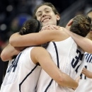 Connecticut's Breanna Stewart, center, embraces teammates Kelly Faris, left, and Heather Buck, right, at the end of a regional final game against Kentucky in the NCAA college basketball tournament in Bridgeport, Conn., Monday, April 1, 2013. Connecticut won 83-53.(AP Photo/Jessica Hill)