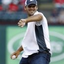 Dallas Cowboys quarterback Tony Romo winds up to throw the ceremonial first pitch before a baseball game between the Seattle Mariners and the Texas Rangers, Wednesday, May 30, 2012, in Arlington, Texas. (AP Photo/Tony Gutierrez)