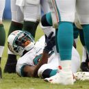 Miami Dolphins running back Reggie Bush holds his leg after being injured during the first half of an NFL football game against the New York Jets, Sunday, Sept. 23, 2012, in Miami. (AP Photo/Wilfredo Lee)