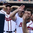 Atlanta Braves' David Ross, left, and Brian McCann welcome Freddie Freeman to the dugout after a solo home run in the first inning of a baseball game against the St. Louis Cardinals Wednesday, May 30, 2012, in Atlanta. Freeman, wearing new glasses, was back in the lineup after missing several games with vision problems. (AP Photo/John Bazemore)