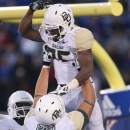 Baylor Bears running back Lache Seastrunk, top, is hoisted into the air by Spencer Drango (58) after scoring in the first quarter of an NCAA college football game against the Kansas Jayhawks, Saturday, Oct. 26, 2013, in Lawrence, Kan. (AP Photo/Ed Zurga)